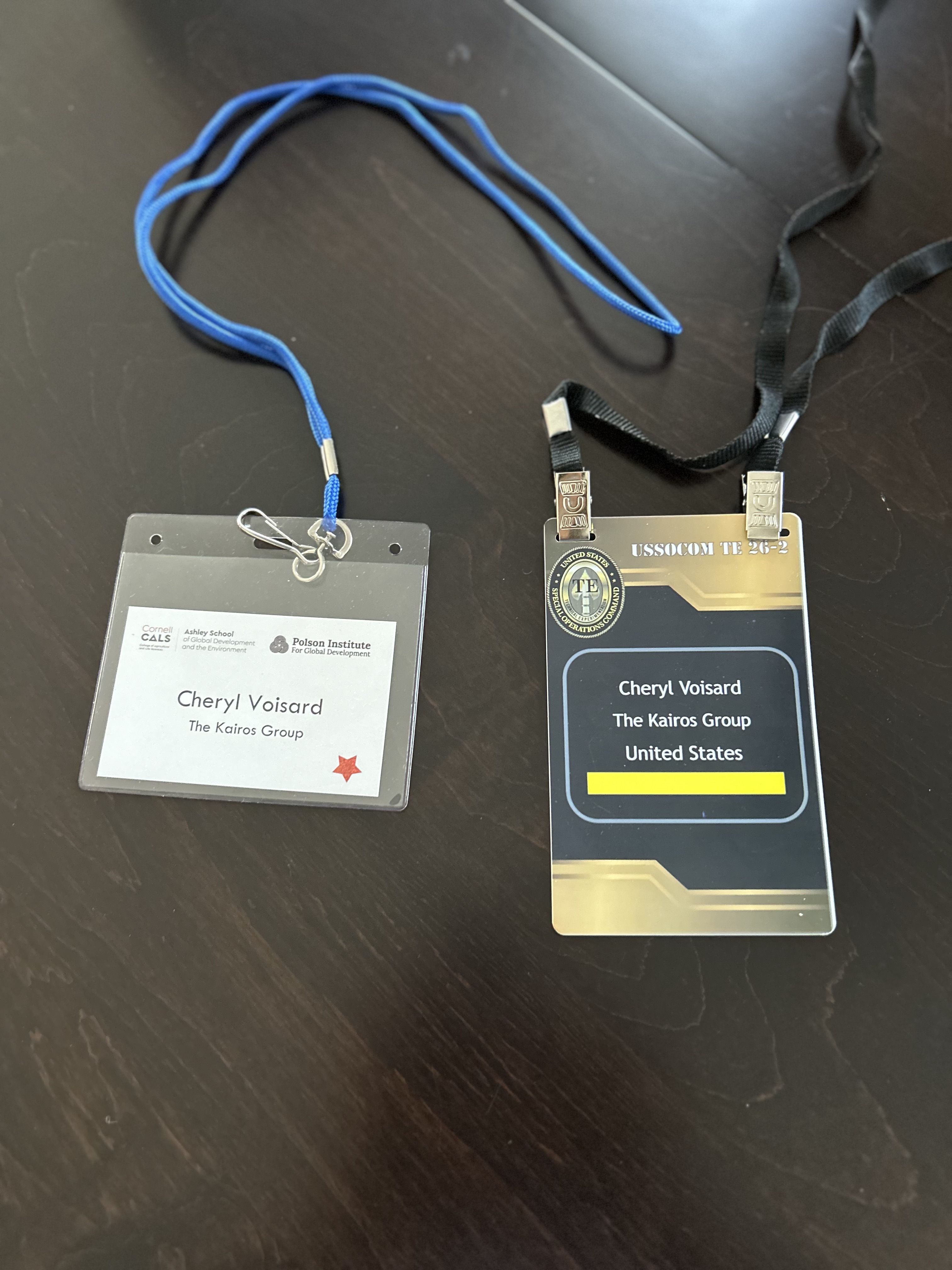 Conference credentials from the Polson Institute 25th Anniversary Symposium at Cornell and USSOCOM TE 26-2, side by side.